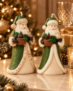 Duas velas Papai Noel com Passarinho de manto verde sobre superfície reflexiva, com árvore de Natal iluminada e bolas douradas ao fundo